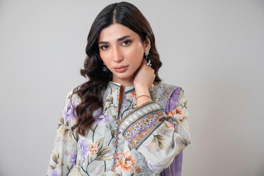 Woman wearing a floral embroidered outfit with a white background