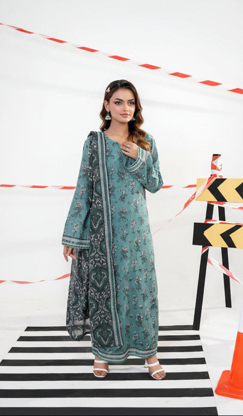 Woman modeling a traditional outfit with printed shirt, dupatta, and cambric trousers on a white background.