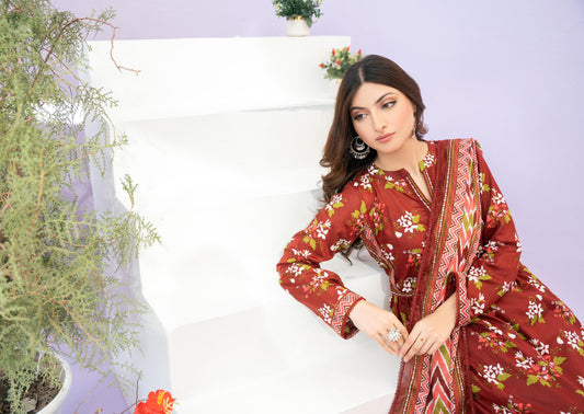 Woman in a red floral outfit sitting on a white couch with plants around.