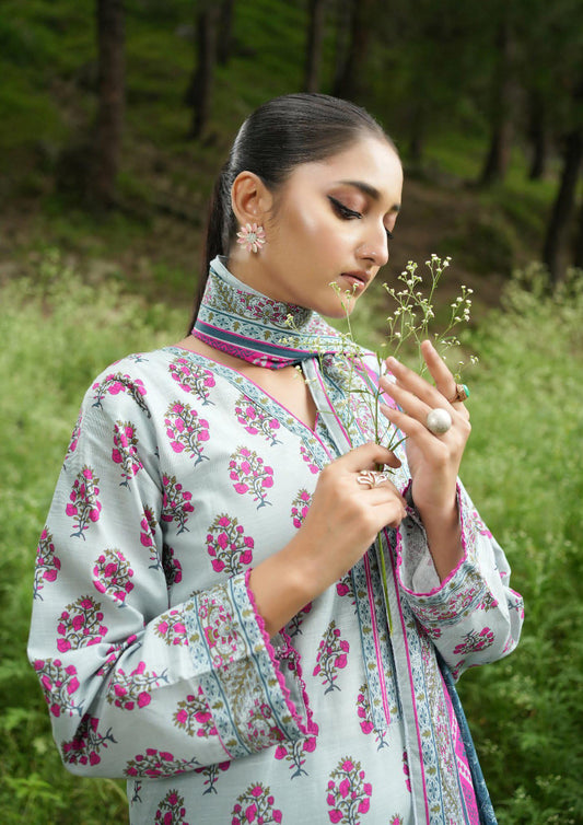 Woman in a floral dress holding a flower in a natural setting