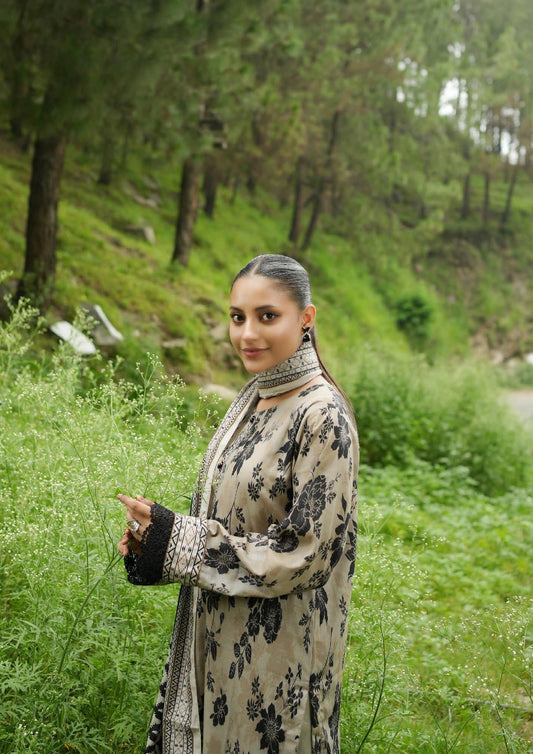 Woman in a floral dress standing in a grassy area with trees in the background