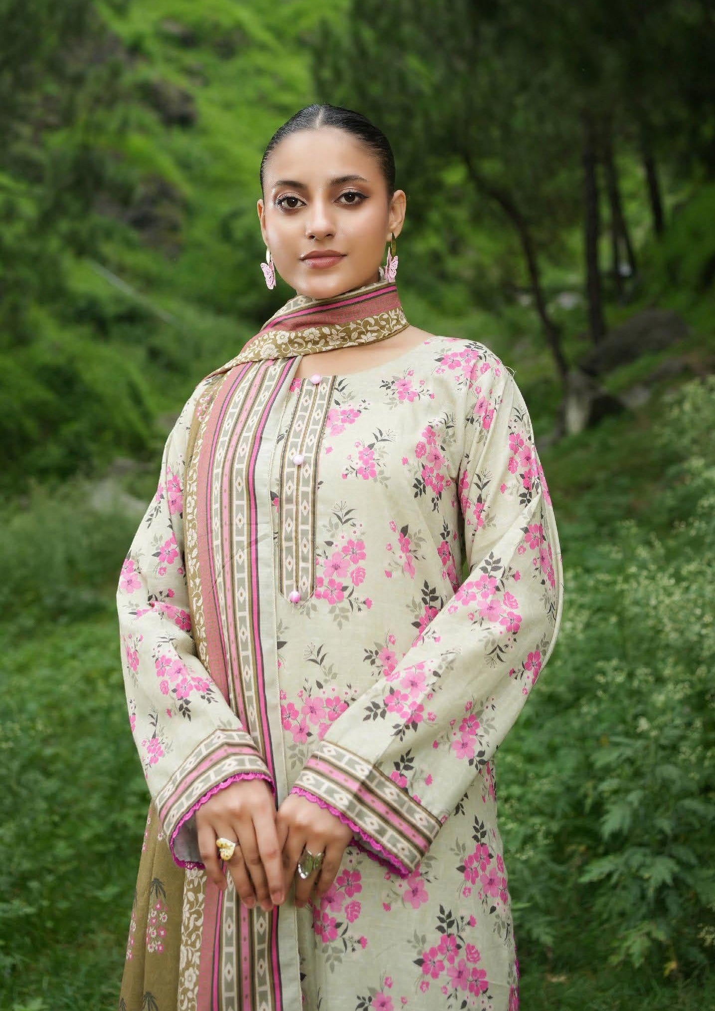 Woman wearing a floral traditional outfit with a green natural background